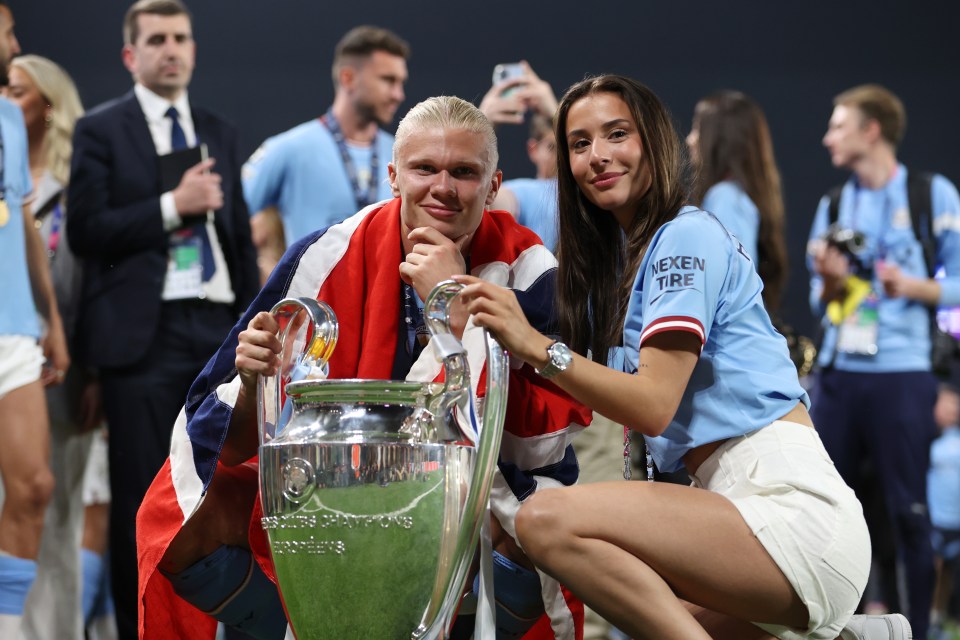 Erling Haaland celebrates with the UEFA Champions League trophy and his girlfriend.