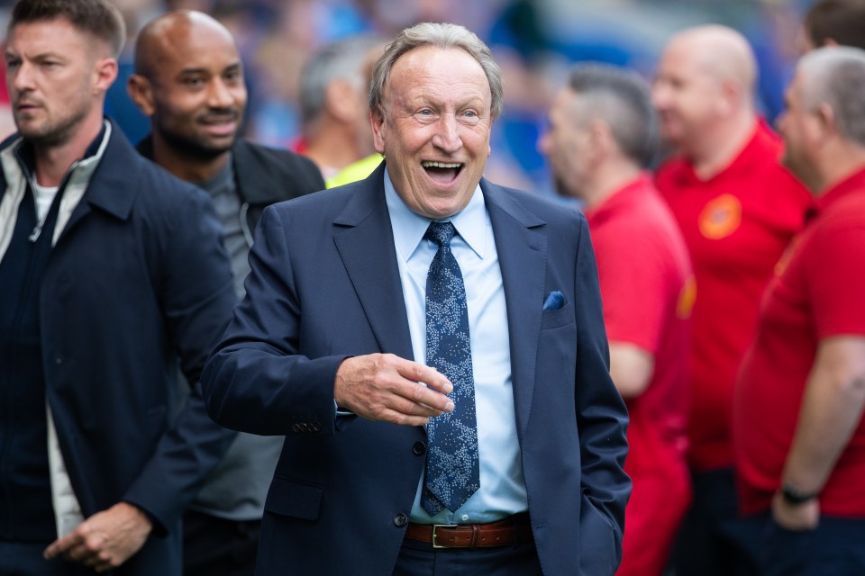 Neil Warnock, former Cardiff City manager, smiling at a sporting event.