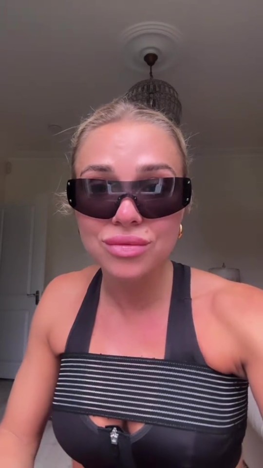 Gabby Allen wearing sunglasses and a sports bra.