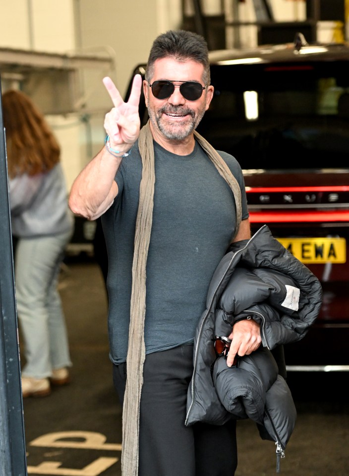 Simon Cowell giving a peace sign.