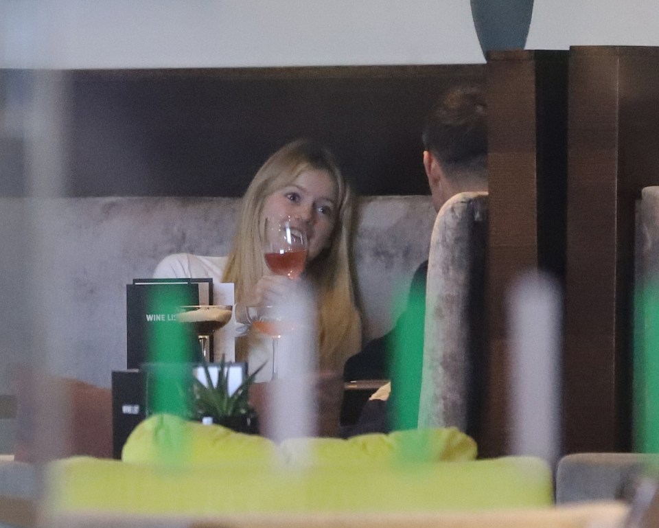 Woman drinking a cocktail with a man at a restaurant.