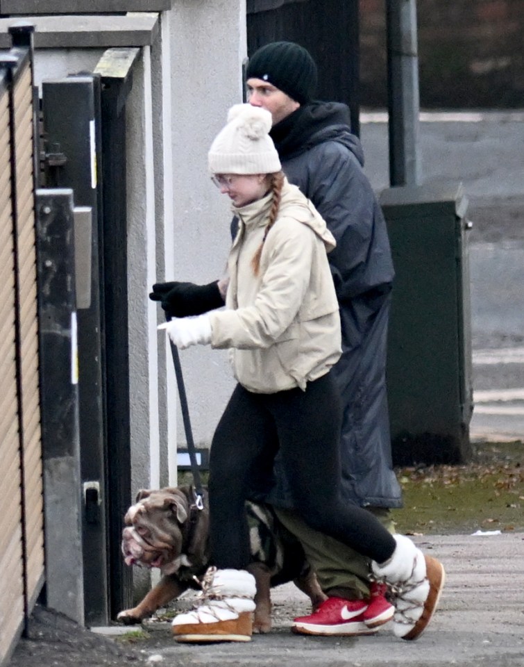 Couple walking a bulldog.