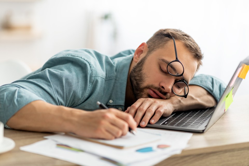 Overworked man sleeping at his desk.