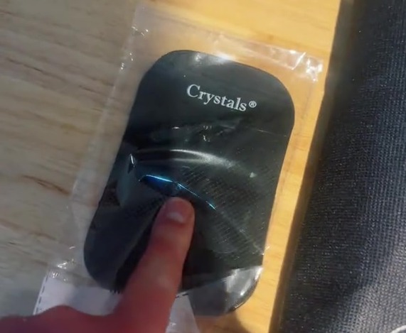 Crystals branded black device in plastic packaging.