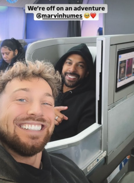 Two men smiling on a plane.