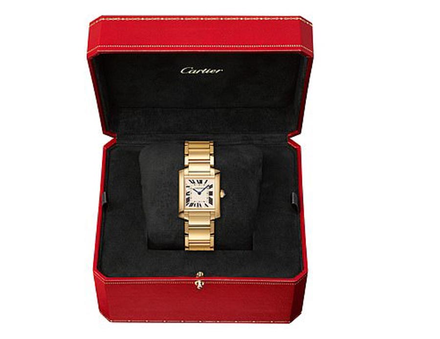 Gold Cartier watch in its red box.