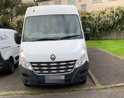 White van parked in a driveway.