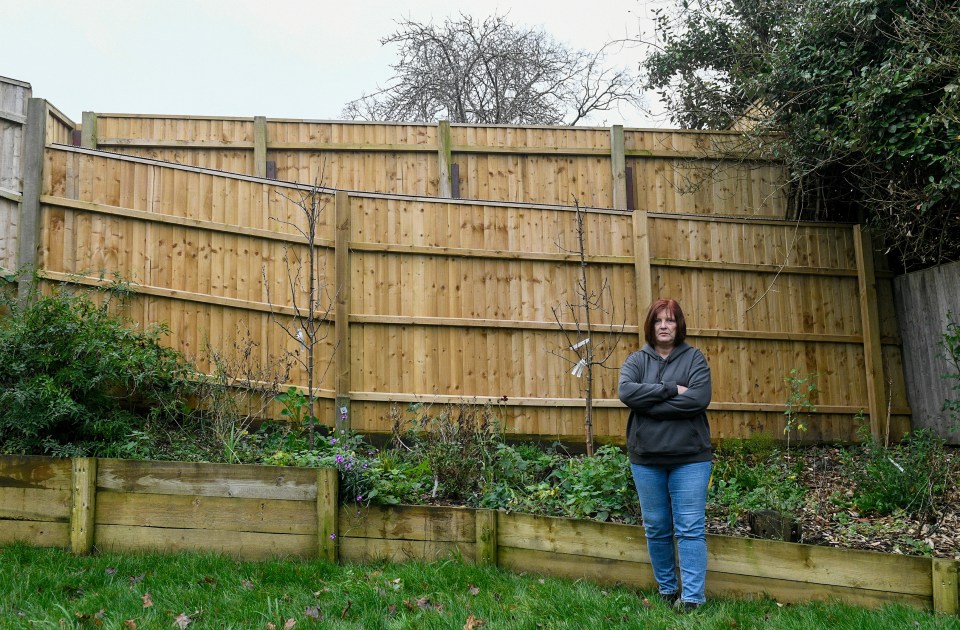 Alison Lawrence in front of the fences between the two gardens