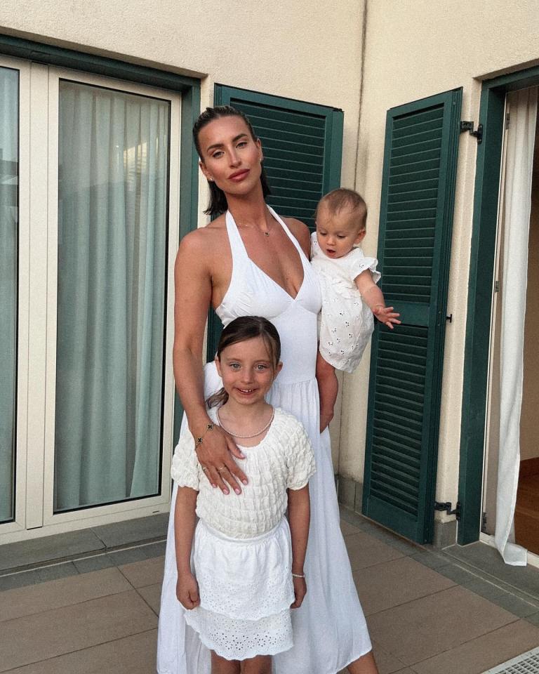 A woman and her two daughters in white dresses.