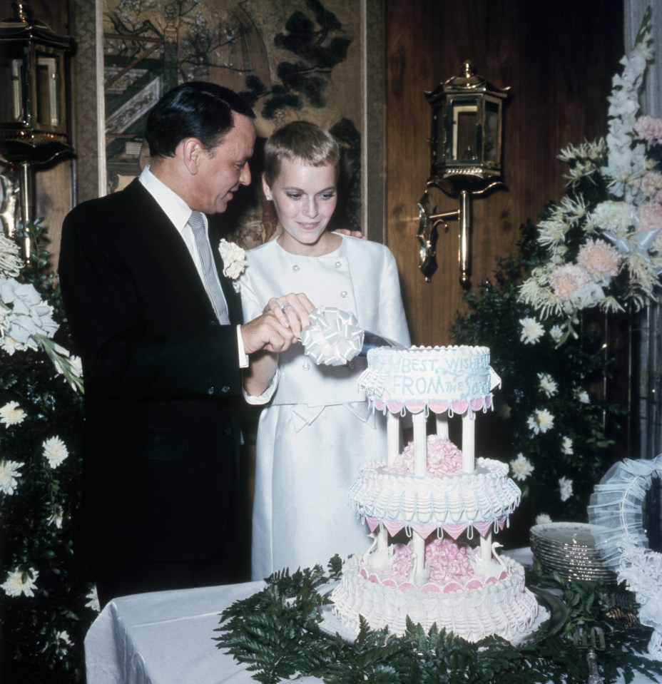 Frank Sinatra and Mia Farrow cutting their wedding cake.