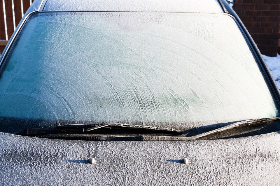 Frost covering a car windshield and hood.