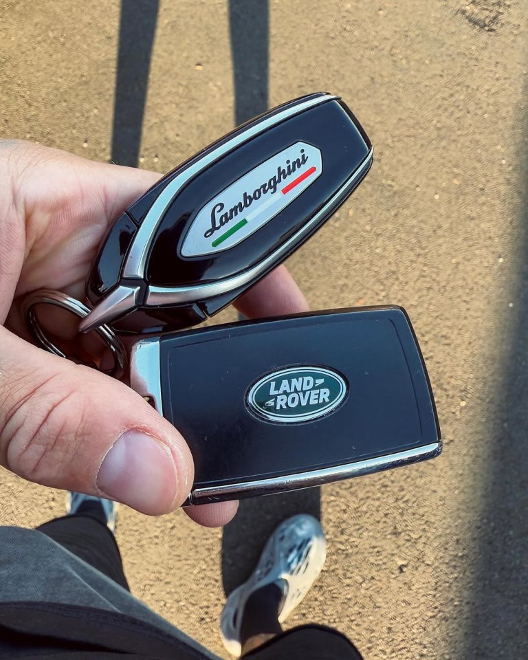 Person holding Lamborghini and Land Rover car keys.