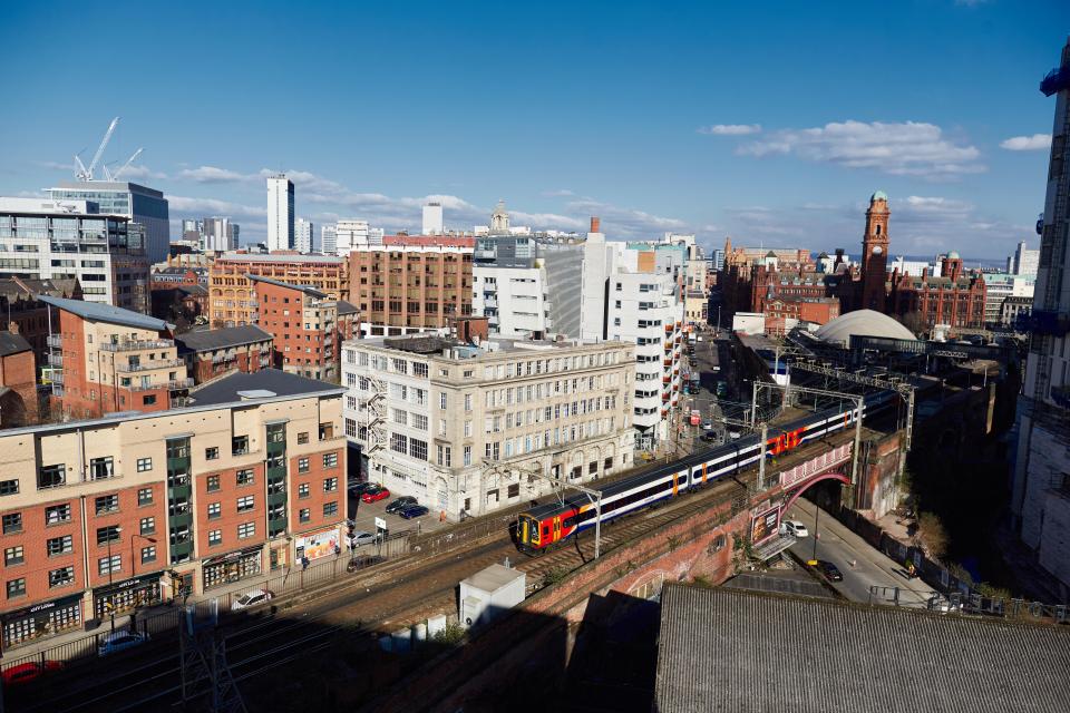 Train passing through Manchester skyline.