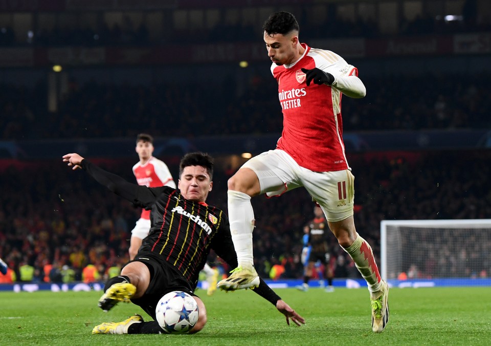 Arsenal's Gabriel Martinelli challenges RC Lens' Abdukodir Khusanov for the ball.