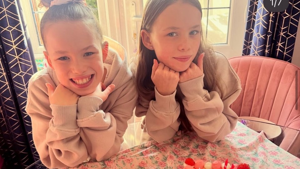 Two young girls sitting at a table.