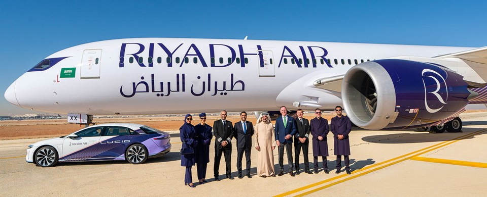 Riyadh Air plane with staff and Lucid Air vehicle.