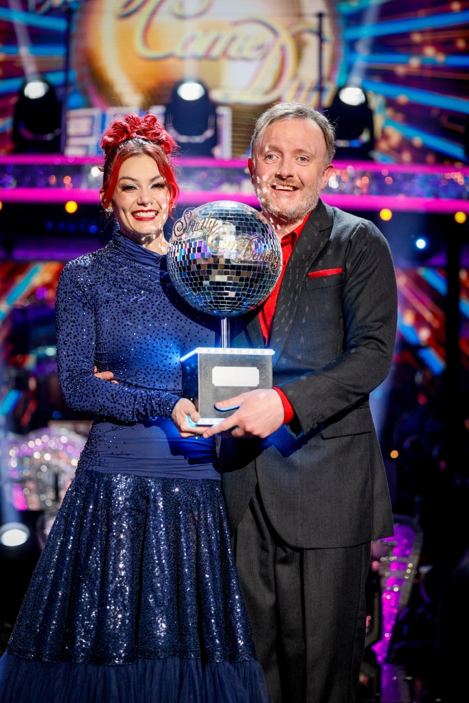 Chris McCausland and Dianne Buswell holding the Strictly Come Dancing glitterball trophy.