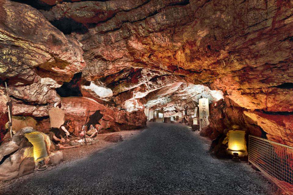 Kent's Cavern, Torquay, Devon: interior view showing a pathway through the cave with displays depicting prehistoric life.