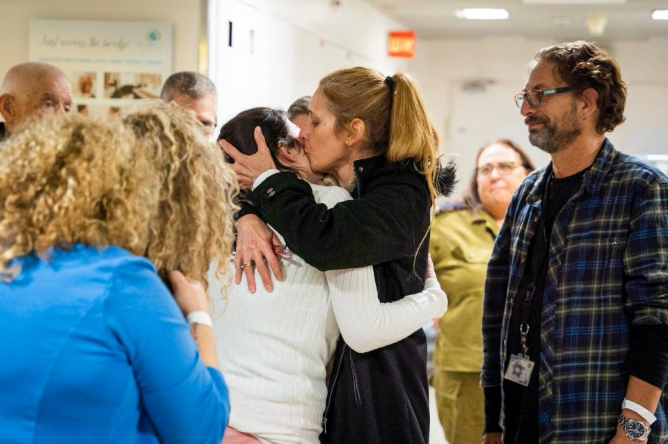 A released Israeli hostage is embraced by a family member at a hospital.