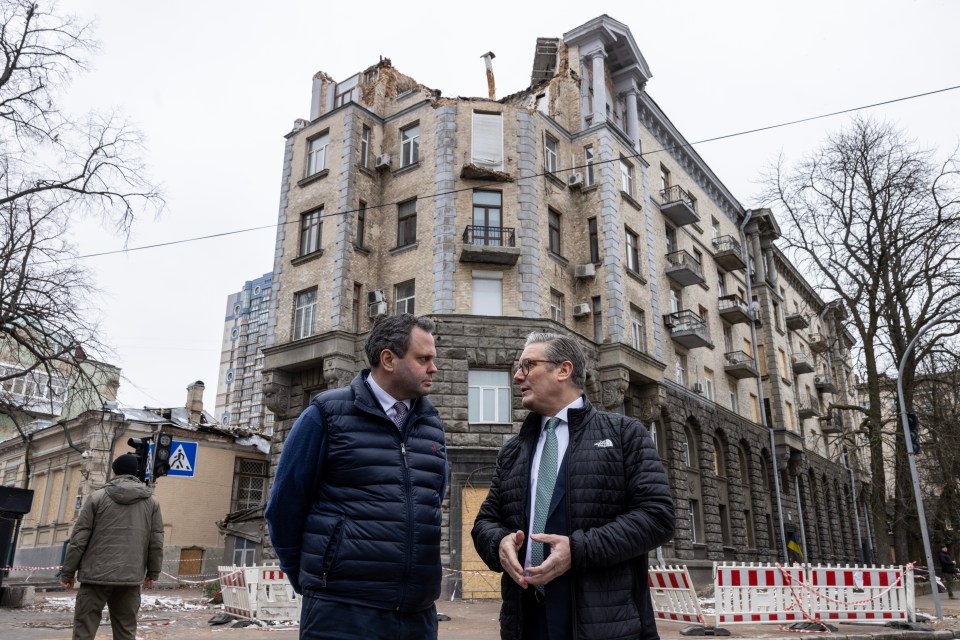 Harry Cole and Keir Starmer in Ukraine in front of a damaged building.