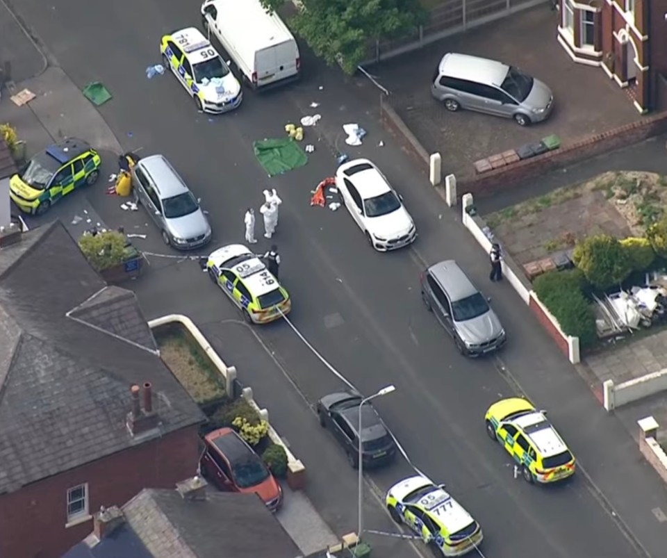 Aerial view of a crime scene with police cars and forensic investigators.