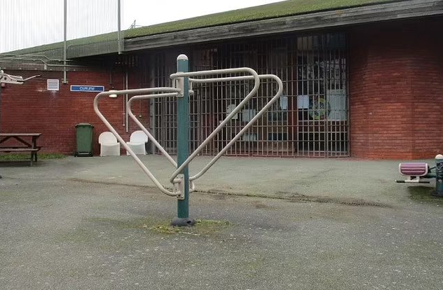 Outdoor exercise equipment outside a brick building.