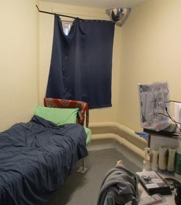 HMP Feltham cell with bed, television, and curtain.