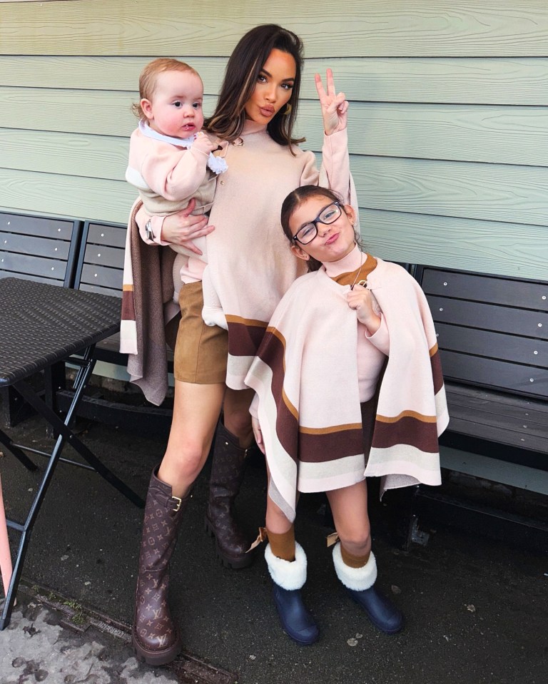 A woman and her two daughters posing for a Christmas photo.