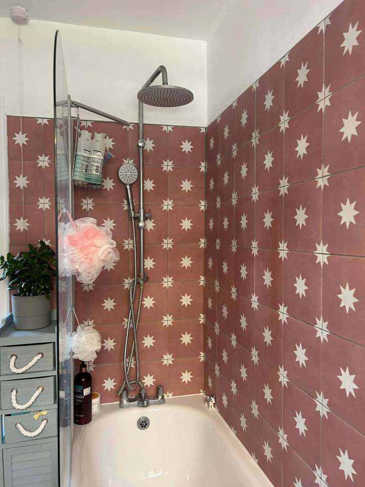 Bathroom makeover with pink star-patterned tiles, shower, and bathtub.