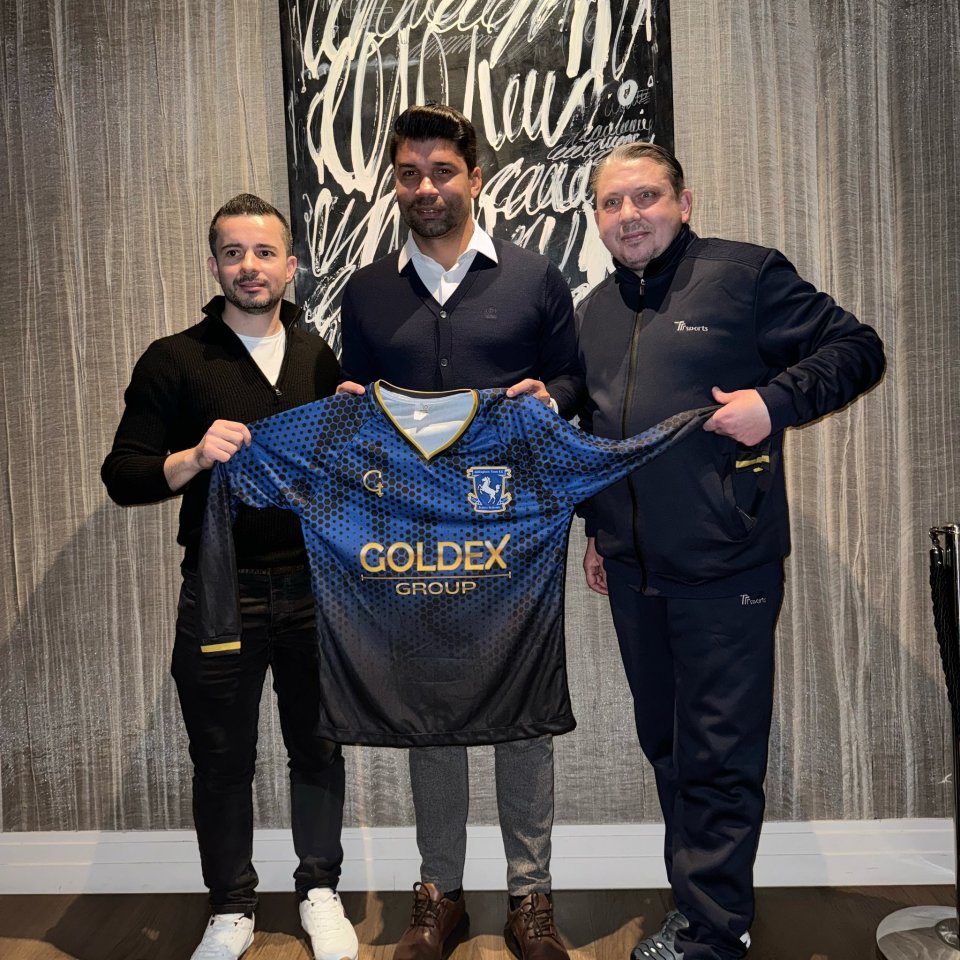 Three men holding a Goldex Group soccer jersey.