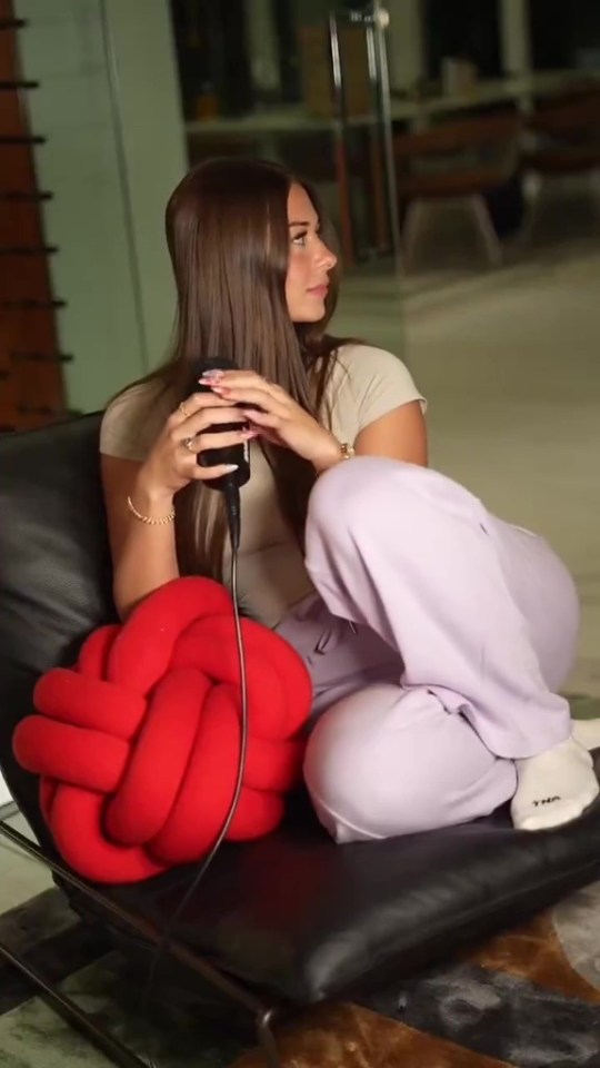 Woman sitting and holding a microphone.