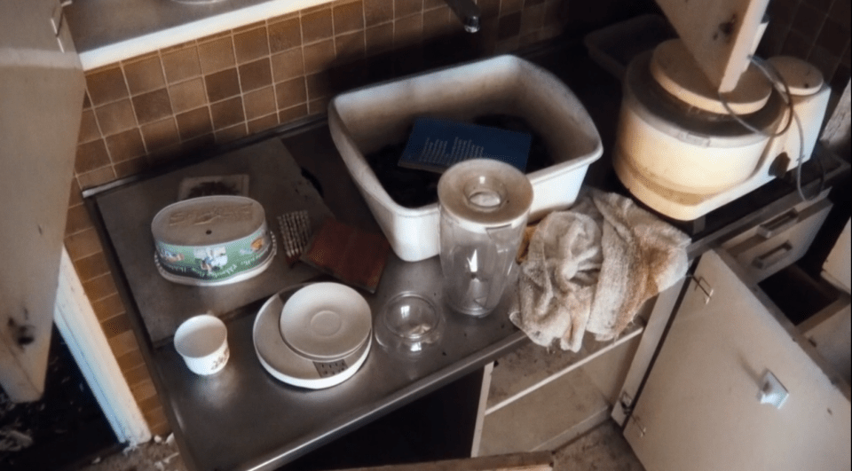 Messy kitchen counter with food containers, kitchen scales, and appliances.