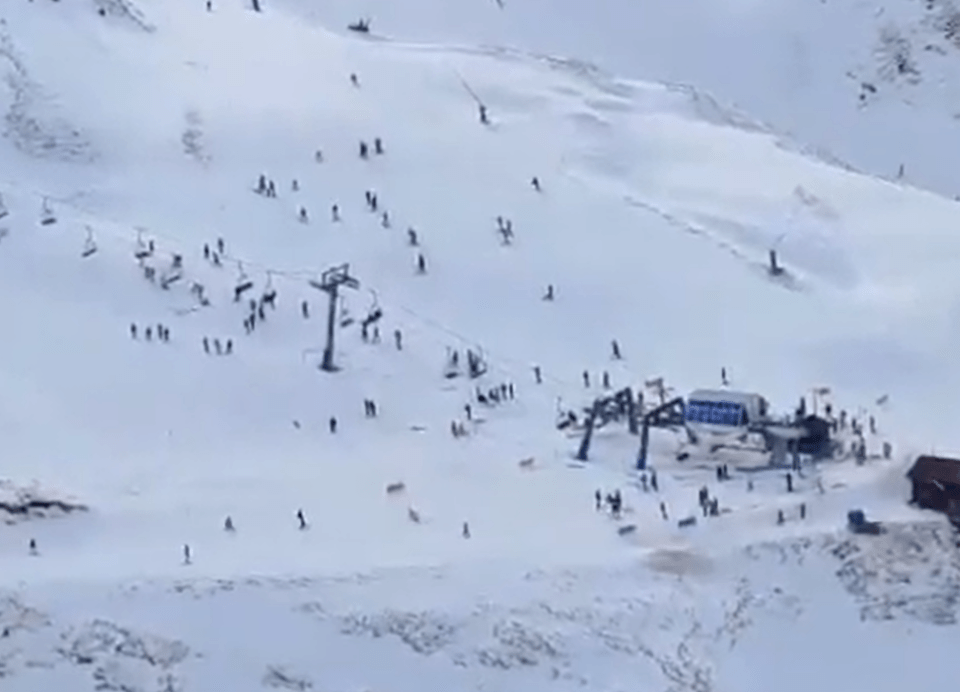 Aerial view of skiers and snowboarders on a snowy mountain slope.