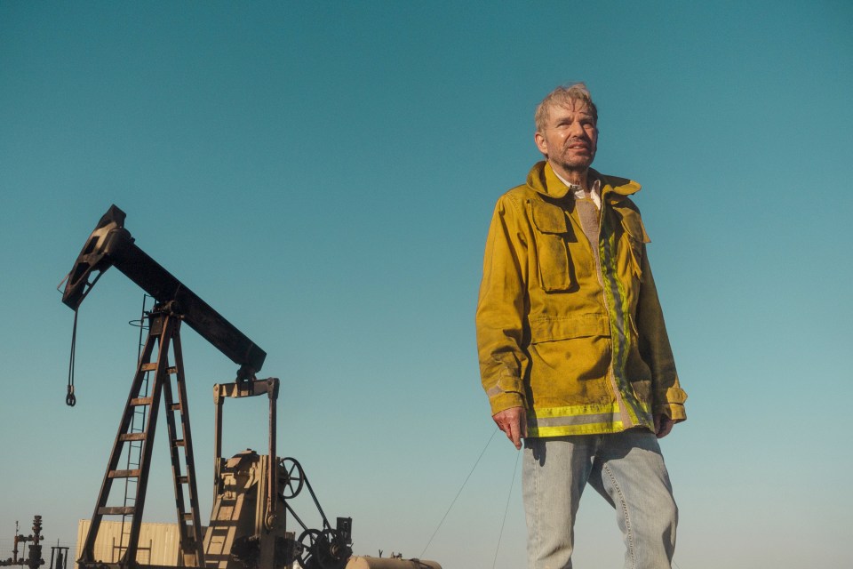 Billy Bob Thornton as Tommy Norris in the Paramount+ series "Landman," standing near an oil pump jack.