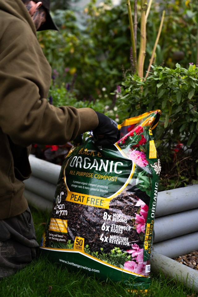 Person adding peat-free compost to garden.