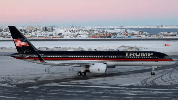 Trump-branded airplane on a snowy tarmac.