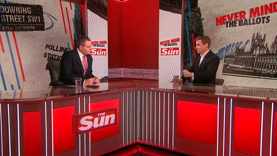 Two men sitting at a The Sun news desk discussing the election.