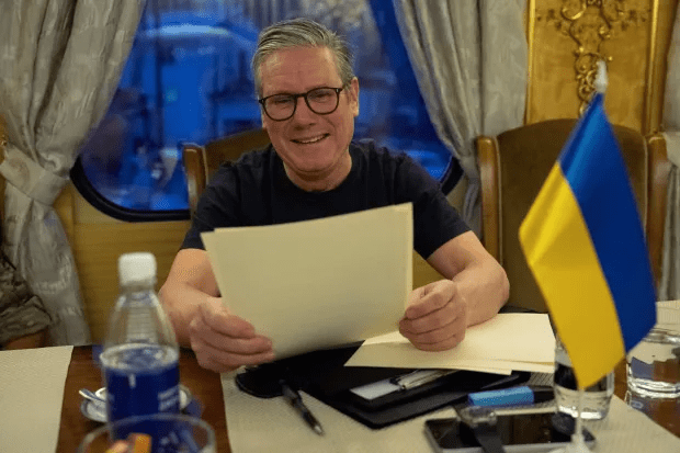 Man reviewing documents at a table with a Ukrainian flag.