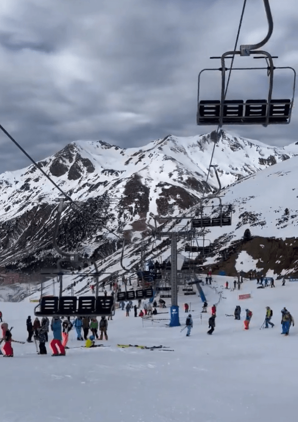 Ski lift and skiers on a snowy mountain.