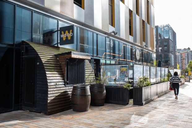 Exterior view of Wood restaurant with outdoor seating.