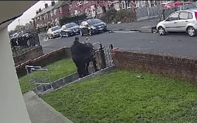 Person wheeling a bin down a driveway.