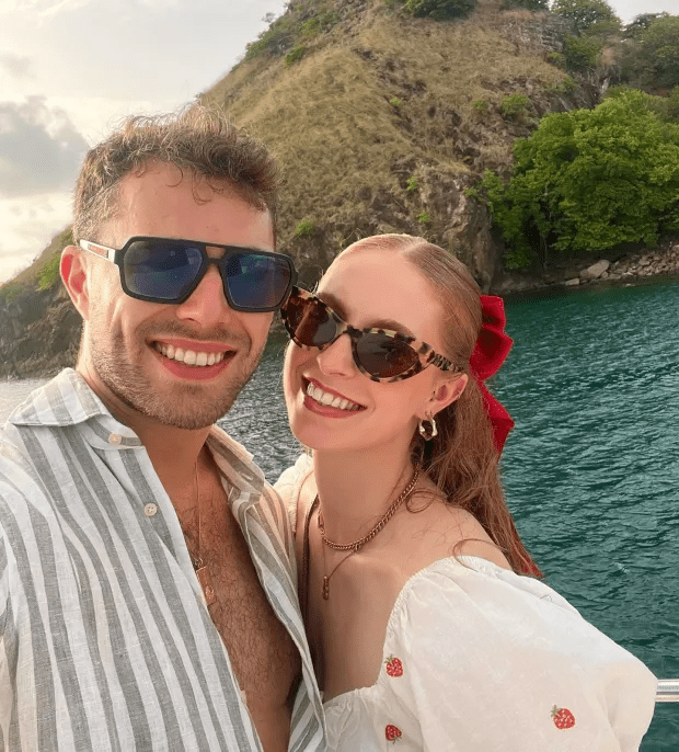 Couple smiling for a selfie on a boat.