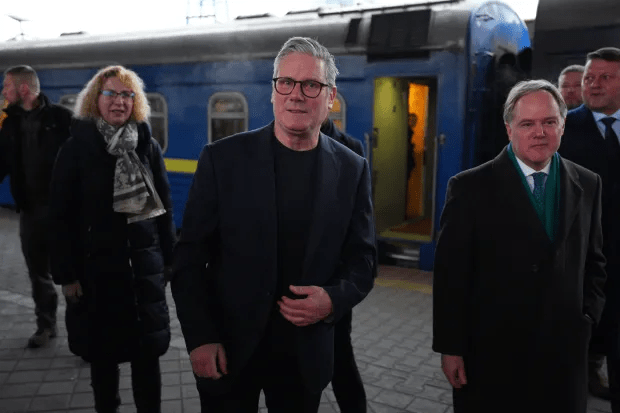 Three people walking near a train.