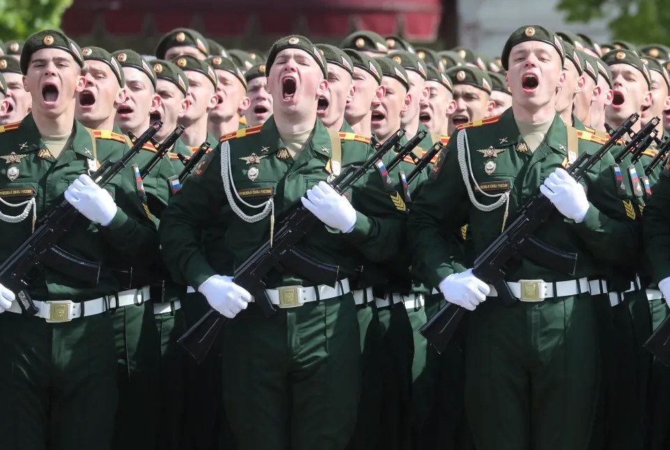 Soldiers in uniform holding rifles.