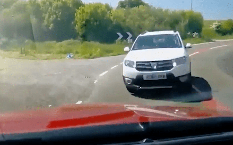 White SUV turning on a road.