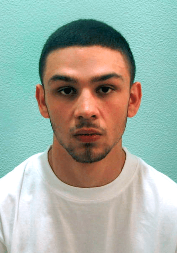 Mugshot of a man with short dark hair wearing a white t-shirt.