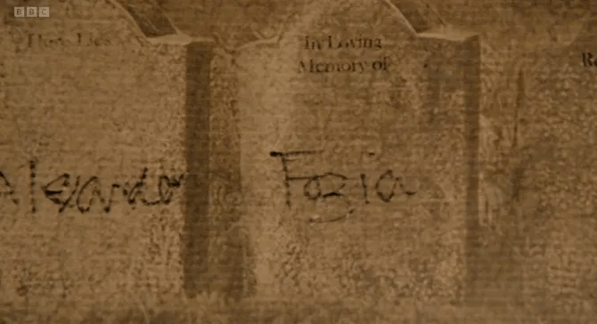 Close-up of weathered gravestones with inscriptions.