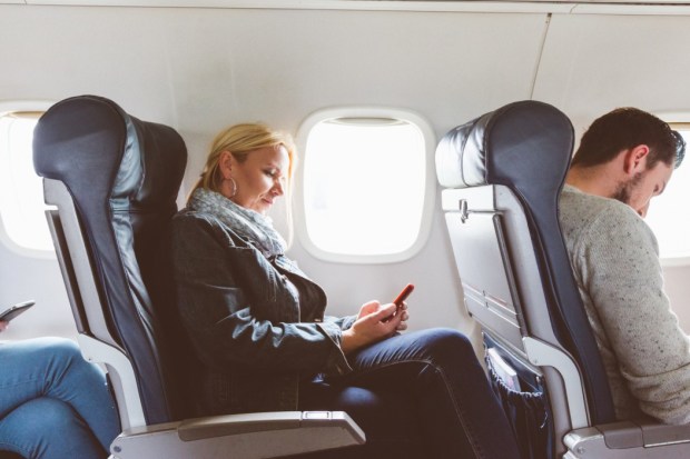 Woman using a mobile phone on an airplane.