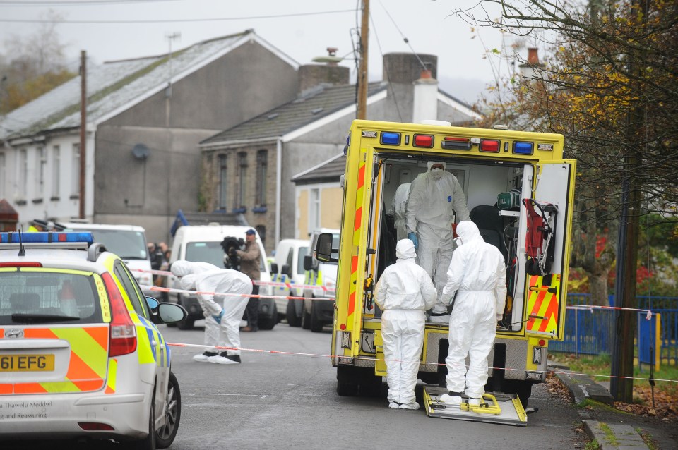 Emergency responders in protective suits at a crime scene.