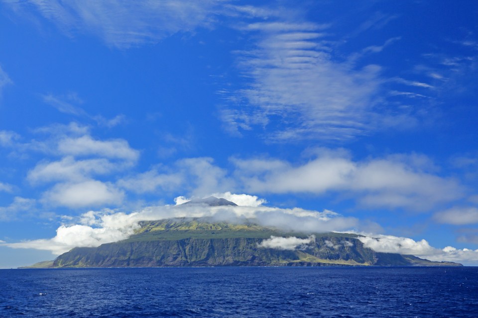 Tristan da Cunha island viewed from the south, partially covered in clouds.